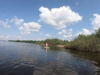 Naked girl riding on sup board